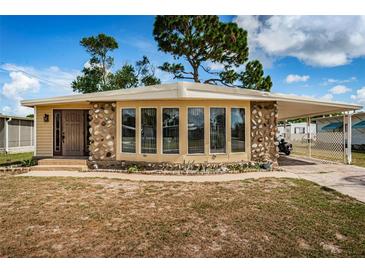 Charming home featuring a unique stone facade and a covered carport, perfect for outdoor living at 185 New England Ave # 33, Palm Harbor, FL 34684