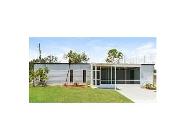 View of the home's exterior, featuring a screened-in porch and well-maintained lawn at 2054 Pennsylvania Ave, Englewood, FL 34224