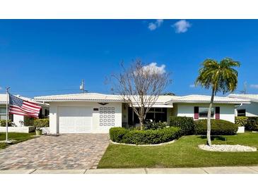 Charming single-story home with a well-maintained lawn and an American flag waving in the breeze at 3745 100Th N Pl # 3745, Pinellas Park, FL 33782