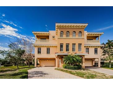 Attractive three-story home with two-car garage and manicured lawn at 1500 Ember Ln, Tarpon Springs, FL 34689