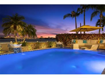 Backyard pool area with a covered outdoor seating area and gorgeous bay views at 295 Bayside Dr, Clearwater Beach, FL 33767