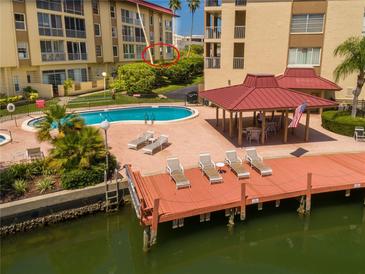 Resort-style pool, dock, and patio furniture at waterfront community at 105 Island Way # 121, Clearwater Beach, FL 33767