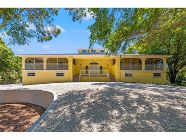 Beautiful yellow house with a large front porch and mature landscaping at 9660 90Th Ave, Seminole, FL 33777