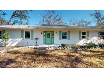Charming home featuring a vibrant green door and matching shutters, complemented by well-maintained landscaping at 679 Lake Maggiore S Blvd, St Petersburg, FL 33705