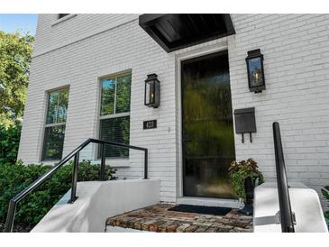 Modern white brick home with black door and stylish light fixtures at 423 21St N Ave, St Petersburg, FL 33704