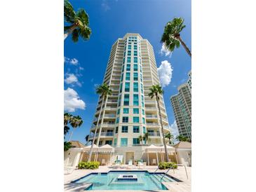 Upscale building featuring plentiful balconies and a beautiful pool area with palm trees at 1180 Gulf Blvd # 2204, Clearwater Beach, FL 33767