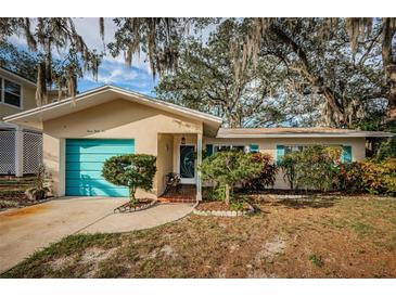 Charming single-story home with teal garage door and landscaped yard at 335 Tucker St, Safety Harbor, FL 34695