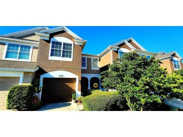 Townhouse exterior with landscaping and a two-car garage at 10254 Red Currant Ct, Riverview, FL 33578
