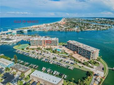 Aerial view of waterfront property with marina, Gulf access, and resort-style amenities at 1 Key Capri # 102E, Treasure Island, FL 33706