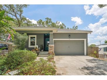 Gray house with teal door, stone accents, and a two-car garage at 131 Pennsylvania Ave, Palm Harbor, FL 34683