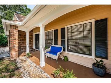 Inviting front porch with a cozy blue bench and tasteful landscaping, creating a welcoming entry at 3482 Rolling Trl, Palm Harbor, FL 34684