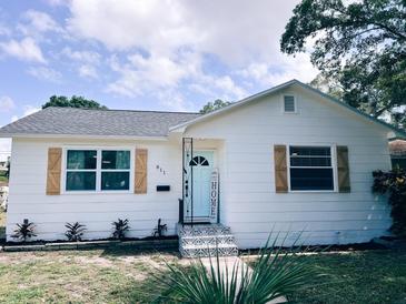 Charming white house with light blue door, wood shutters, and landscaped yard at 811 40Th S Ave, St Petersburg, FL 33705