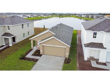 Tan one-story house with a two-car garage, viewed from above at 5552 Logan Cave Ave, Wimauma, FL 33598