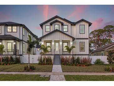 Two-story modern farmhouse with gray and white exterior, landscaping, and walkway at 125 48Th N Ave, St Petersburg, FL 33703