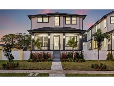 Two-story house with gray and white exterior, front porch, and landscaped yard at 135 48Th Ave, St Petersburg, FL 33703