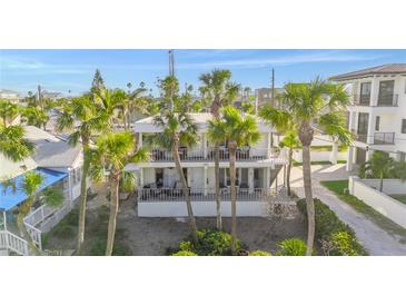 Inviting multi-story home featuring balconies and lush palm trees, offering a tropical and serene living environment at 108 14Th Ave # 3, St Pete Beach, FL 33706