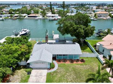 Aerial view of waterfront home with private dock and solar panels at 11600 7Th E St, Treasure Island, FL 33706