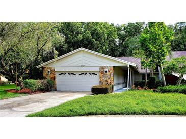 Single-story house with a two-car garage and nicely landscaped lawn at 3529 Tanglewood Trl, Palm Harbor, FL 34685