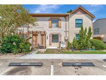 Tan two-story townhome with brown shutters and a small front yard at 103 Brigadoon Dr, Clearwater, FL 33759