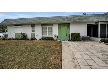 Front view of a single story home with green door and landscaping at 7787 39Th N Ter # 7787, St Petersburg, FL 33709