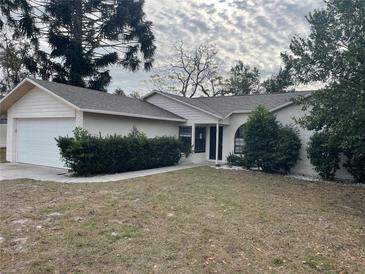 Brick house with a white garage door and well-manicured hedges at 10608 Bucks Run, New Port Richey, FL 34654