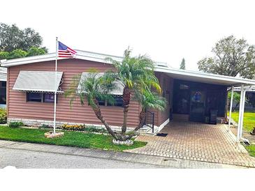 Brown mobile home with landscaped yard and awning at 283 Pelican N Dr, Oldsmar, FL 34677