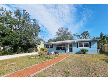 Cute blue house with a landscaped yard and walkway at 1345 Young Ave, Clearwater, FL 33756