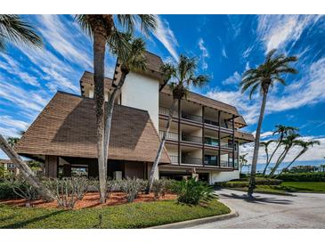 Exterior view of condo building with palm trees and parking at 3021 Countryside Blvd # 28A, Clearwater, FL 33761