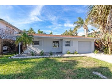 White brick ranch house with a one car garage and nicely landscaped lawn at 17734 1St E St, Redington Shores, FL 33708