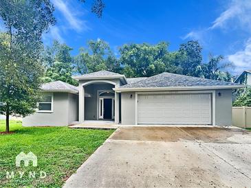 Newly constructed one-story home with attached garage and well-manicured lawn at 12731 N Ola Ave, Tampa, FL 33612