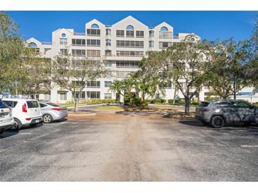 Building exterior with parking lot and landscaping at 2333 Feather Sound Dr # A203, Clearwater, FL 33762