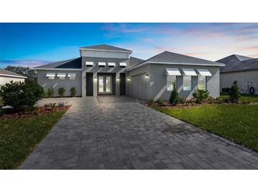 Curb appeal abounds in this beautiful home, featuring a paver driveway and nicely landscaped yard at 8874 Players Dr, Weeki Wachee, FL 34613