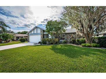 Single-story home with stone facade, attached garage, and well-manicured lawn at 3631 Player Dr, New Port Richey, FL 34655