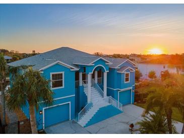 Luxury waterfront home with a two-car garage, stunning sunset views, and a spacious driveway at 7516 Gulf Way, Hudson, FL 34667