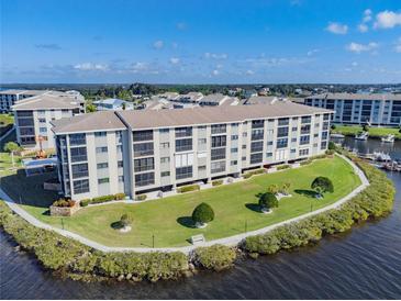 Aerial view of waterfront condo building with lush landscaping and parking at 8150 Brent St # 746, Port Richey, FL 34668