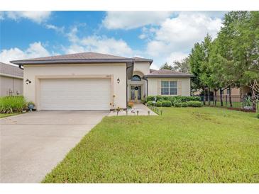 One-story home with a two-car garage and well-maintained lawn at 13455 Niti Dr, Hudson, FL 34669