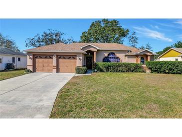 Single-story house with two-car garage and well-manicured lawn at 4483 Plumosa St, Spring Hill, FL 34607