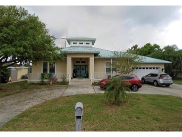 House exterior featuring a two-story home with a green roof and attached two car garage at 732 Kingston Ct, Apollo Beach, FL 33572