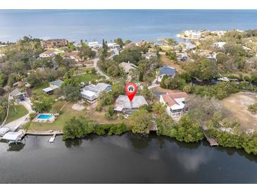 Aerial view of waterfront home with private dock and lush landscaping at 2014 Cove Ct, Holiday, FL 34691