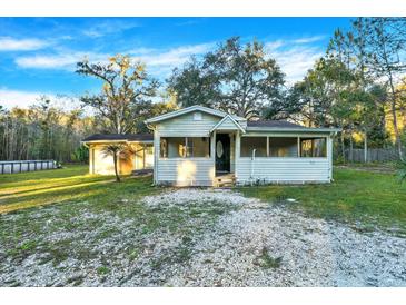 Quaint one-story house with a covered porch and large backyard at 21000 Nina Ln, Brooksville, FL 34601