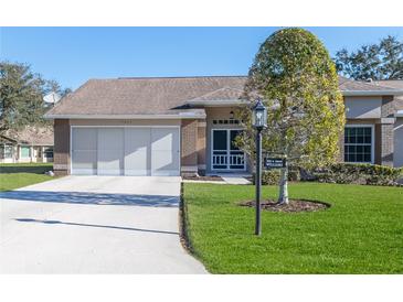 Brick house with two-car garage and nicely landscaped lawn at 7425 Nature Walk Dr, Spring Hill, FL 34606
