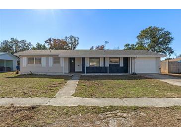 Ranch style home with a gray exterior, white shutters, and a two-car garage at 9126 Lester Ln, Spring Hill, FL 34606