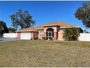 Brick house with brown roof, screened porch, and fenced backyard at 15131 Eastwood Trl, Brooksville, FL 34604
