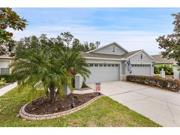 Two-car garage, landscaped yard, and attractive curb appeal at 7633 Deer Path Ln, Land O Lakes, FL 34637