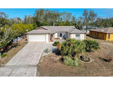 Aerial view of a single-Gathering home with a driveway and landscaping at 8177 Philatelic Dr, Spring Hill, FL 34606