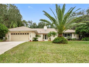 Single-story home with a two-car garage and mature landscaping at 7368 Royal Oak Dr, Spring Hill, FL 34607