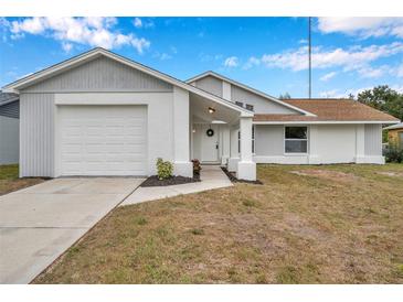 Newly renovated single-story home with gray and white exterior, and a two-car garage at 2643 Narcissus Dr, Holiday, FL 34691
