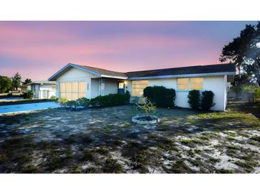 Ranch-style house with a flat roof, light-colored exterior, and a small front yard at 7714 Jasmine Blvd, Port Richey, FL 34668