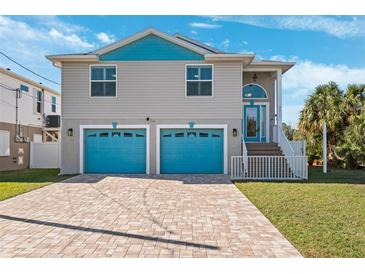 Two-story house with teal accents, two-car garage, and a paved driveway at 3215 Rose Arbor Dr, Hernando Beach, FL 34607