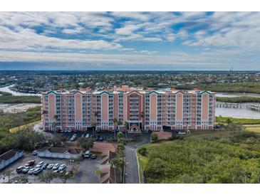 Aerial view of a waterfront condo building with parking and lush landscaping at 4516 Seagull Dr # 417, New Port Richey, FL 34652